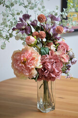 A photograph of beautiful flowers arranged in a vase, taken indoors