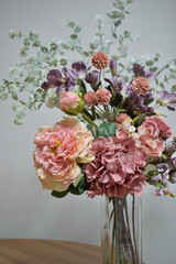 A photograph of beautiful flowers arranged in a vase, taken indoors