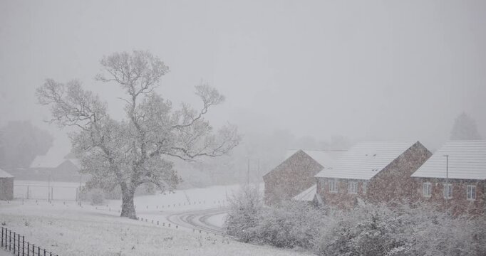 Snow falling on a cold winter day in England in a typical village