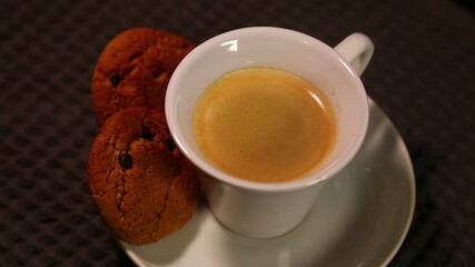 Cup of espresso coffee with oatmeal cookies with chocolate, sweet dessert. Morning tasty healthy breakfast. Closeup warm video - Powered by Adobe