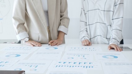 Professional women analyzing financial charts, discussing business strategy in modern light office, in collaborative corporate environment. Business people concept