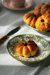 Pumpkin shaped yeast buns with marzipan filling served on vintage plates with natural Autumn decorations on the table.
