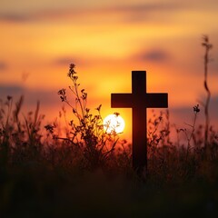 Cross silhouetted against a sunset in a grassy field, symbolizing hope and remembrance in the evening light