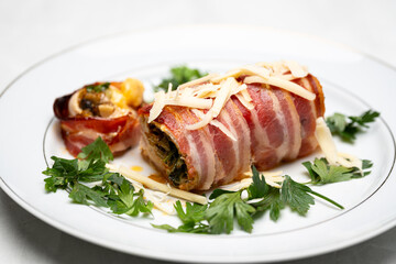 Rolled Chicken Breast with Vegetables Wrapped in Bacon and Garnished with Parsley