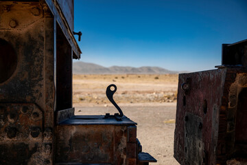 An abandoned locomotive cemetery in Uyuni. Old, rusty, forgotten trains in Bolivia. Sunny day. Blue sky.