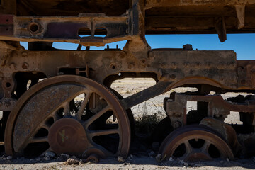 An abandoned locomotive cemetery in Uyuni. Old, rusty, forgotten trains in Bolivia. Sunny day. Blue sky.