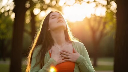Serene Woman in Sunset Park Finds Calm and Gratitude with Hands Over Heart