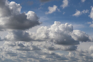 Cloudscape: An expansive view of a sky filled with fluffy, billowing clouds on a bright, sunny day,...