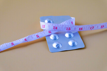 A pills and a measuring tape suggest a journey towards health.