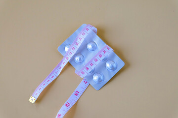 A pills and a measuring tape suggest a journey towards health.