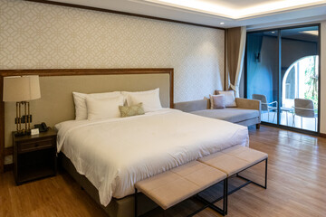 Comfortable and luxurious hotel bedroom interior with a stylish bed, modern furniture, and warm lighting