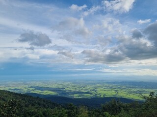 Vast Panorama: A sweeping vista unfolds beneath a dynamic sky filled with fluffy clouds. The photo captures a sense of peace and a feeling of adventure