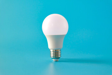 White LED light bulb on color background.