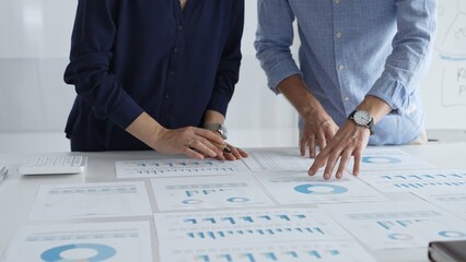 Professional team analyzing financial reports, sharing insights and planning strategic decisions in modern workplace setting. Business people concept