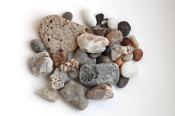 Mixed natural pebbles. Collection of assorted natural pebbles and stones isolated on white, useful for eco and balance concepts.