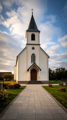 Naklejka premium White church in a graveyard at sunset