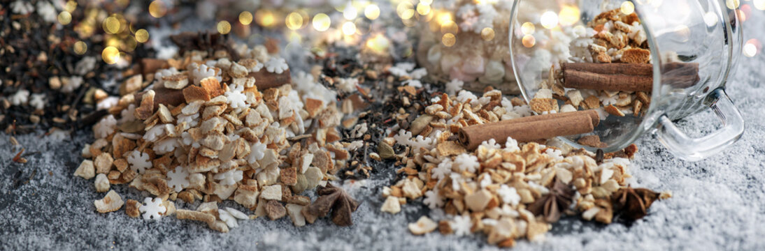 winter hot drink ingredient spiled with spices, sugar and glass cup turn over on snowy background