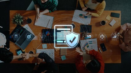 A diverse business team engages in a collaborative discussion focused on data security strategies, enhanced by digital graphics representing analysis and protection. Raster