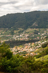 Fototapeta premium Scenic hillside village with terraced fields and lush green mountains.