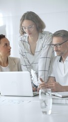 Obraz premium Business people team collaborating on a project, analyzing data on a laptop during a productive office meeting, fostering teamwork and strategic planning