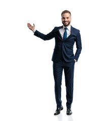 happy elegant man in navy blue suit smiling and presenting to side