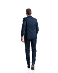 full body picture of mature businessman in navy blue suit walking