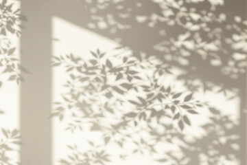 Obraz premium Soft leafy shadows cast on a beige wall with sunlight filtering through, creating a peaceful minimalist nature-inspired design concept background. Ai generative