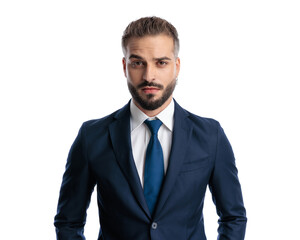 suspicious young man wearing navy blue suit looking forward and frowning