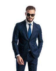 sexy mature guy with sunglasses holding hand in pockets and standing