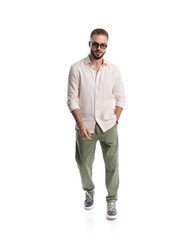 Fototapeta premium casual fashion man with sunglasses walking with hand in pocket