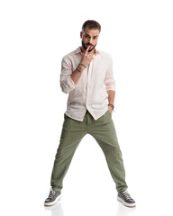 Fototapeta premium cool sensual guy touching lips and posing with hand in pocket