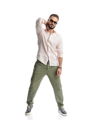 Fototapeta premium cool casual guy with sunglasses holding hand behind neck and posing