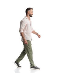 Naklejka premium side view of happy casual man looking to side, smiling and walking