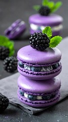 Purple macarons stacked with fresh blueberries and blackberry