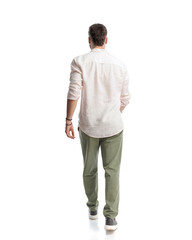 back view of sexy young man in shirt walking in front of white background