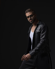 Fototapeta premium cool fashion guy with sunglasses in leather jacket posing in a confident way
