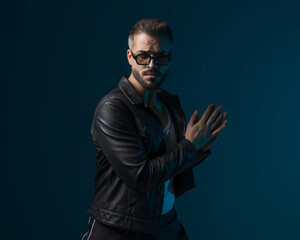 Fototapeta premium sexy young man with sunglasses holding hands to side and posing