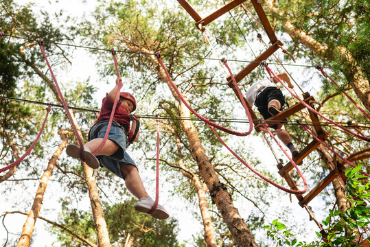 Child crossing rope bridge in adventure park