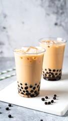 Two iced bubble teas on a white surface