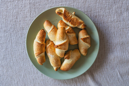 Freshly baked kifla or kipferl bread rolls served on a plate, traditional homemade pastry.