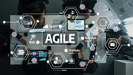 A diverse team actively collaborates in a modern office space, utilizing various digital tools to implement agile methodologies for effective project management and strategic planning. Amity