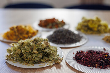 Assorted dried flowers and herbs on paper plates for aromatherapy, tea, natural craft and art therapy