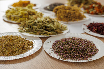 Assorted dried flowers and herbs on paper plates for aromatherapy, tea, natural craft and art therapy