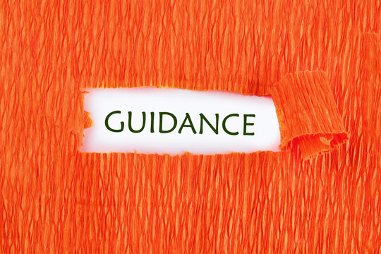 Business concept. The phrase, text, and words of GUIDANCE are written on white paper under orange torn paper