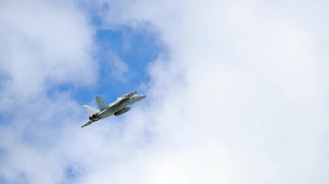 Slow motion view of F-18 fighter jets at full power, engines blazing with afterburners, showcasing military strength, speed, and precision.