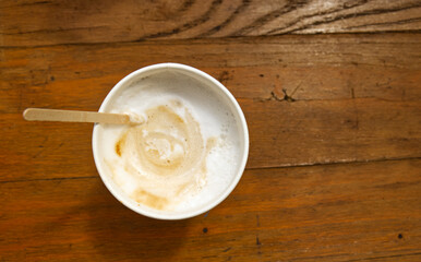 Caffe latte in a paper cup. Caffe latte from a coffee machine from above. Coffee drink for a short break on the road