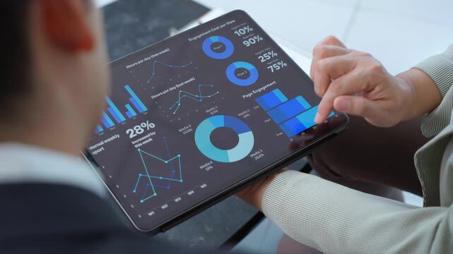 Business colleagues review data on a tablet, discussing performance metrics, market trends, and strategic insights for informed decision making