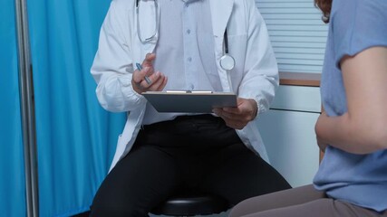 Medical professional holding clipboard standing near patient while explaining diagnosis in clinical examination room with empathetic communication and supportive interaction