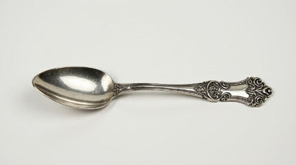 Vintage silver spoon with ornate floral handle and engraved monogram isolated on white background. AI generated.
