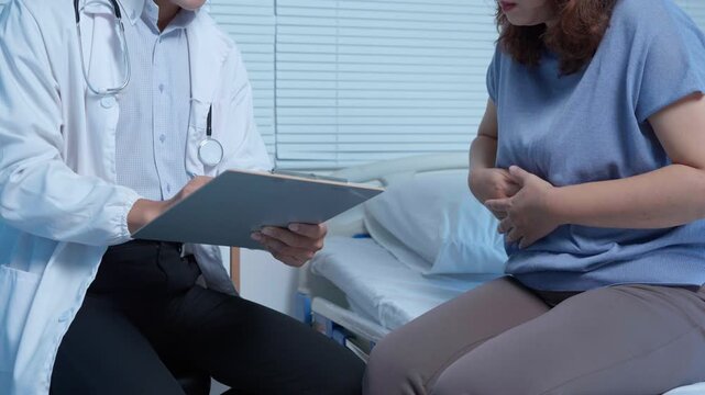 Attentive medical professional listening carefully while female patient describing localized abdominal discomfort during comprehensive health consultation in clinical examination room setting